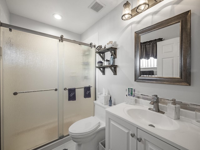 bathroom with tile patterned flooring, vanity, a shower with shower door, and toilet