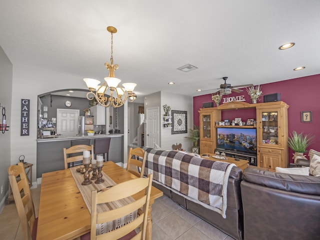 tiled dining area featuring ceiling fan with notable chandelier