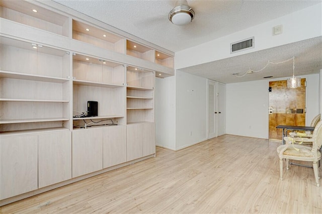 living room with light hardwood / wood-style flooring and a textured ceiling