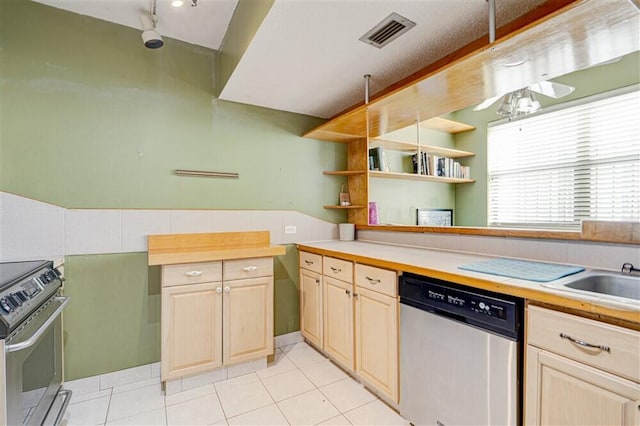 kitchen featuring stainless steel appliances, light brown cabinetry, sink, and light tile patterned floors