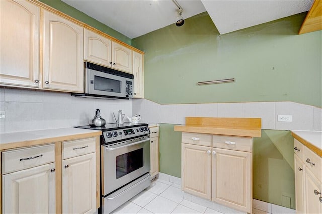 kitchen with stainless steel appliances, light brown cabinets, and light tile patterned floors