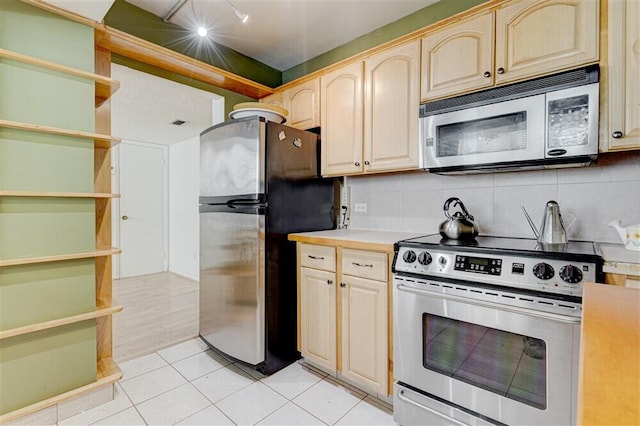 kitchen with tasteful backsplash, light tile patterned flooring, appliances with stainless steel finishes, and light brown cabinetry