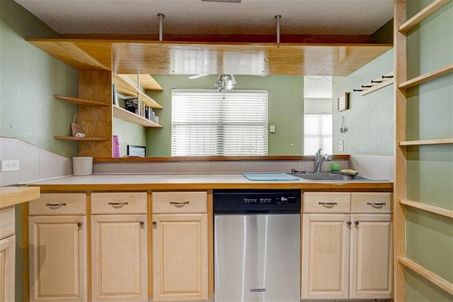 kitchen featuring dishwasher, sink, a textured ceiling, and light brown cabinetry