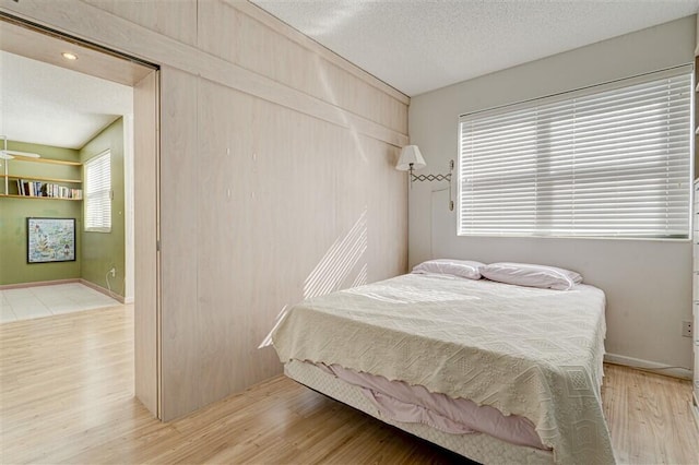 bedroom featuring light hardwood / wood-style flooring and a textured ceiling