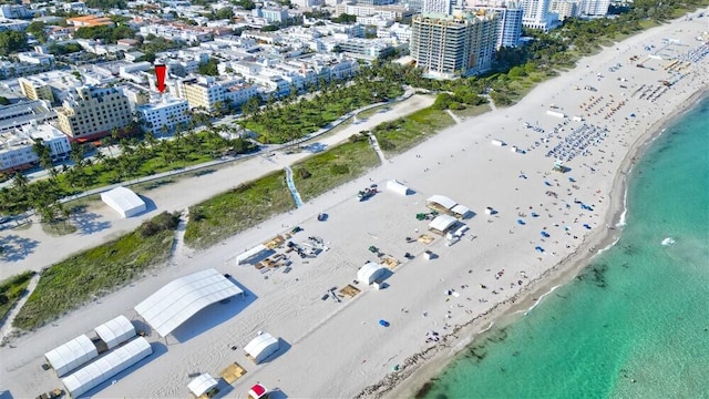 drone / aerial view featuring a beach view and a water view