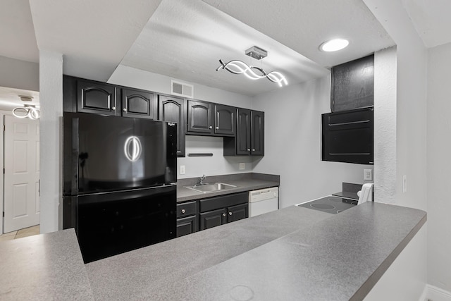 kitchen featuring sink, black refrigerator, white dishwasher, a textured ceiling, and kitchen peninsula