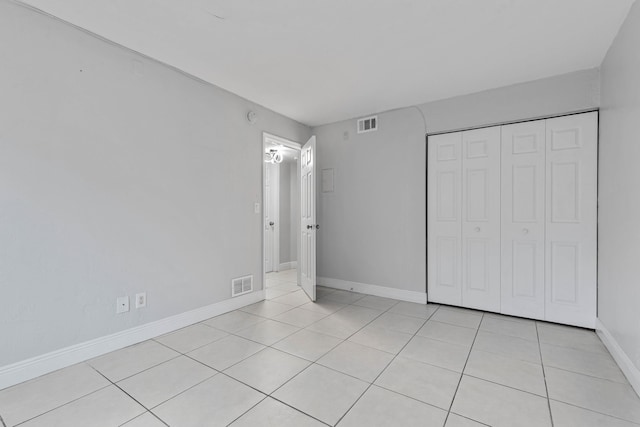 unfurnished bedroom with light tile patterned flooring and a closet