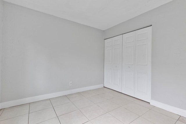 unfurnished bedroom with a closet and light tile patterned floors