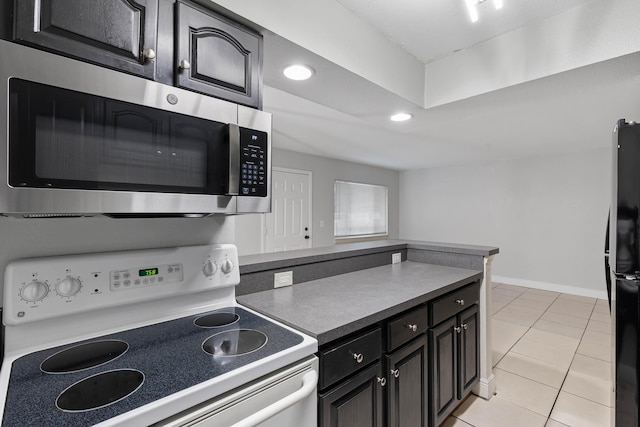 kitchen with light tile patterned floors, black fridge, and white range with electric cooktop