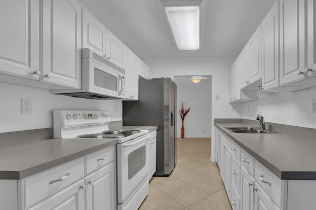 kitchen featuring white cabinets, white appliances, sink, and light tile patterned floors