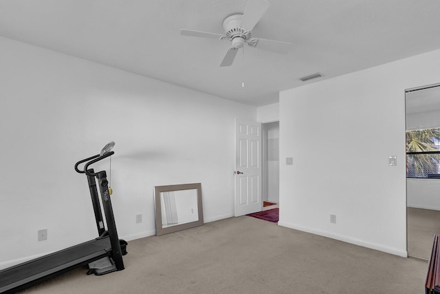 workout area with ceiling fan and light carpet