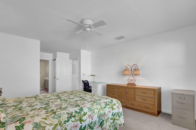 bedroom with ceiling fan, light carpet, and connected bathroom