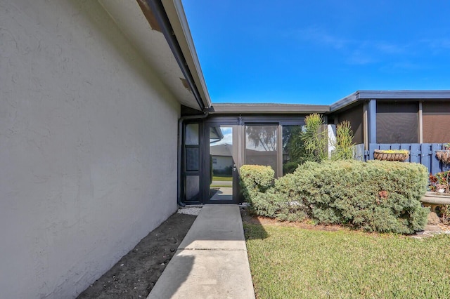 view of exterior entry featuring a yard