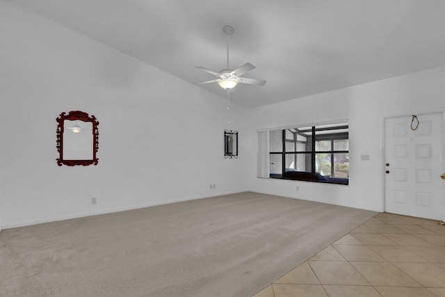 unfurnished living room featuring ceiling fan, light tile patterned floors, and vaulted ceiling