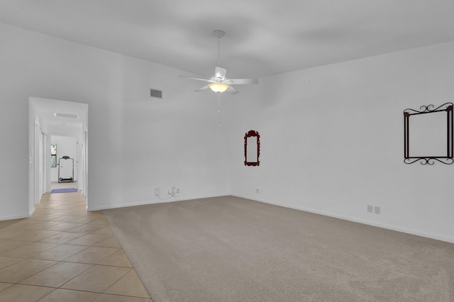 tiled spare room featuring ceiling fan