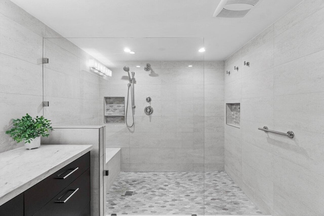 bathroom with vanity and a tile shower