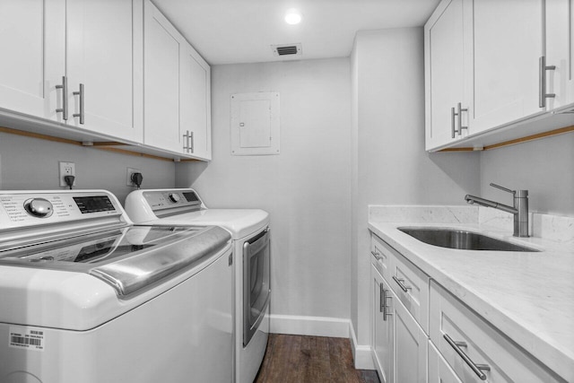 laundry area with cabinets, sink, washing machine and clothes dryer, electric panel, and dark hardwood / wood-style floors