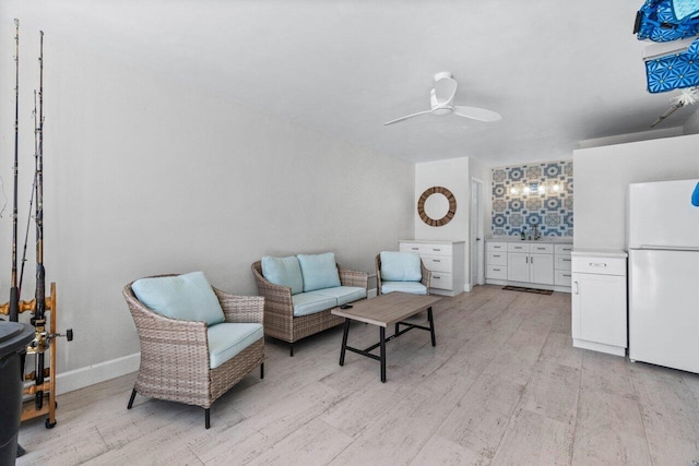 living area featuring light wood-type flooring and ceiling fan