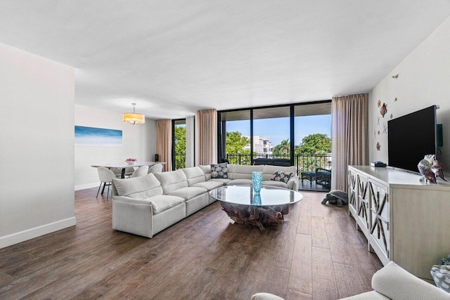 living room featuring hardwood / wood-style floors, a chandelier, and a wall of windows