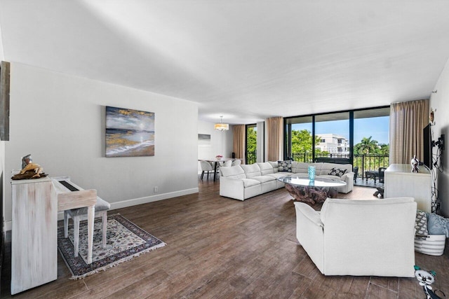 living room featuring dark hardwood / wood-style floors, a wall of windows, and a notable chandelier