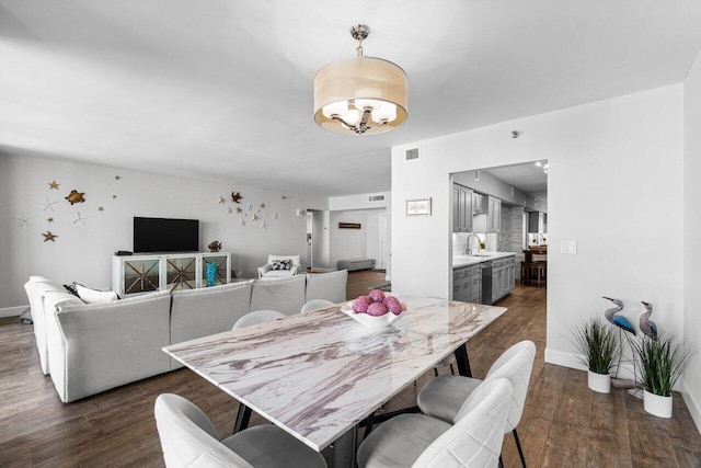 dining room featuring sink and dark wood-type flooring