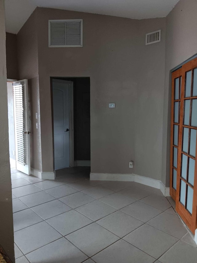 tiled spare room with high vaulted ceiling