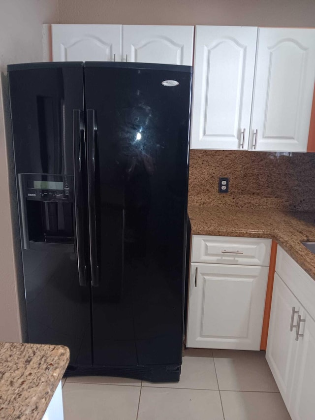 kitchen with white cabinets and black fridge