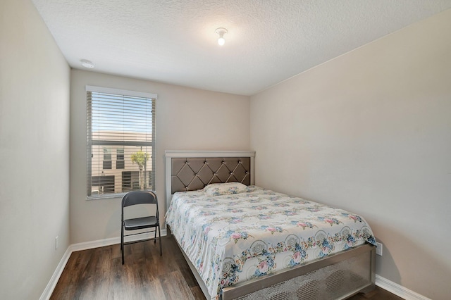 bedroom with dark hardwood / wood-style flooring and a textured ceiling