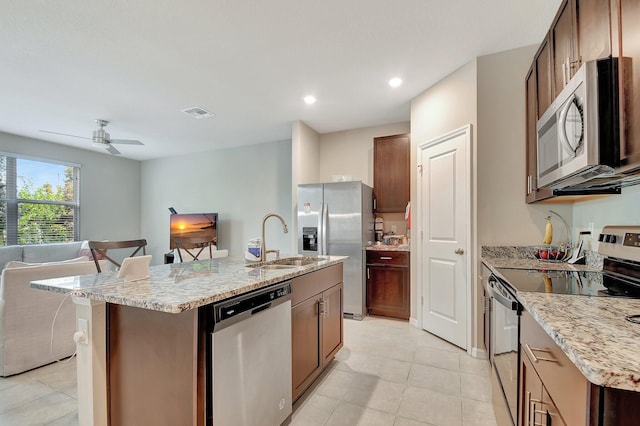 kitchen with sink, ceiling fan, light tile patterned floors, an island with sink, and stainless steel appliances