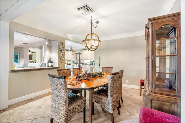 tiled dining space with ceiling fan with notable chandelier