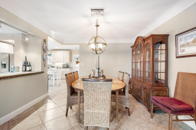 dining area with a chandelier and track lighting