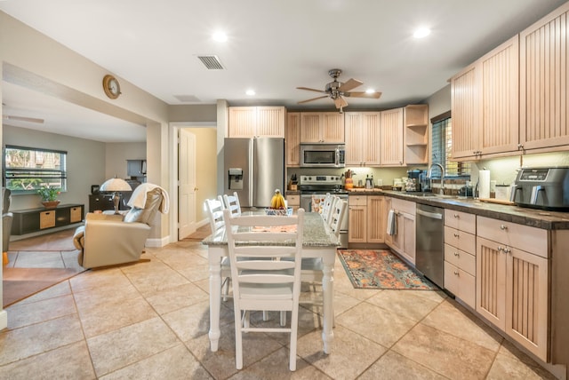 kitchen with light brown cabinetry, stainless steel appliances, ceiling fan, a healthy amount of sunlight, and sink