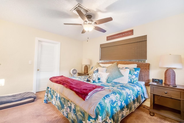 bedroom featuring ceiling fan, a closet, carpet, and a textured ceiling