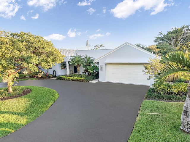 single story home featuring a garage and a front lawn