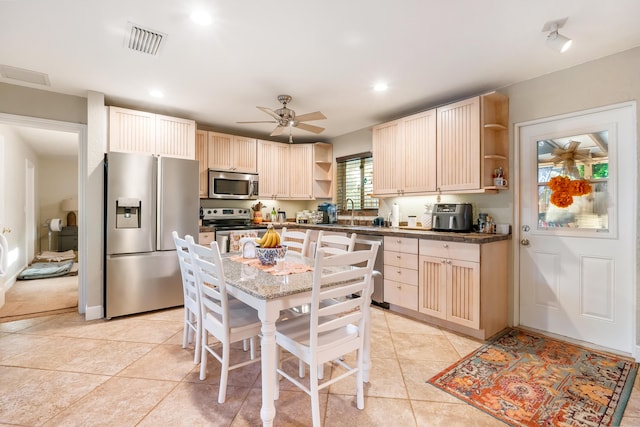 kitchen featuring ceiling fan, light tile patterned floors, light brown cabinetry, and appliances with stainless steel finishes