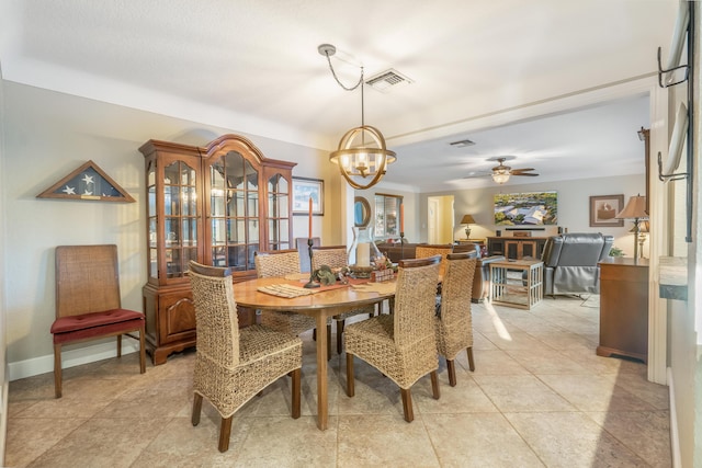 tiled dining area featuring ceiling fan with notable chandelier