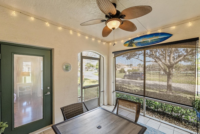 unfurnished sunroom featuring a ceiling fan