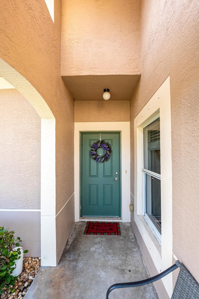 entrance to property with stucco siding