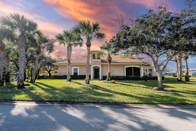 view of front of property featuring stucco siding and a front yard