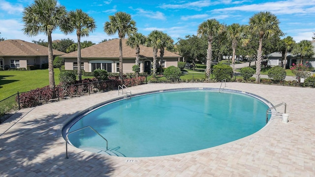 community pool featuring a yard and fence