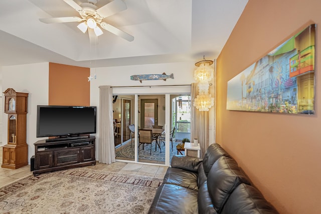 tiled living room with a raised ceiling and ceiling fan with notable chandelier