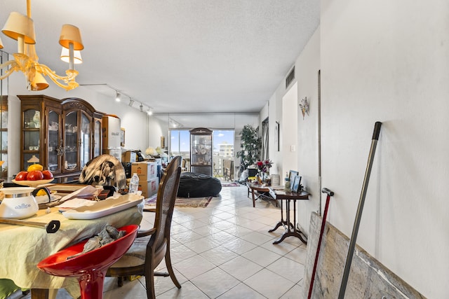 tiled dining area with a notable chandelier and a textured ceiling