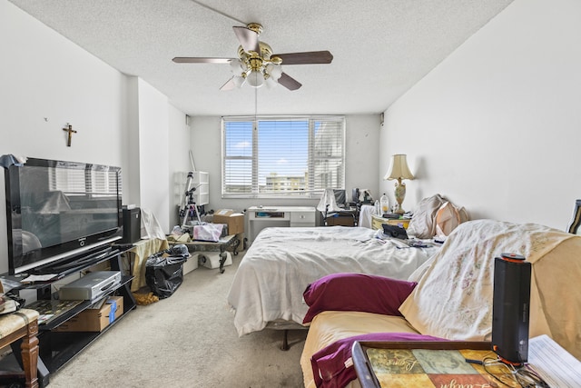 bedroom with ceiling fan, carpet, and a textured ceiling