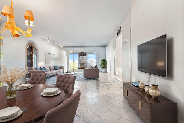 dining area with light tile patterned floors, a chandelier, and track lighting