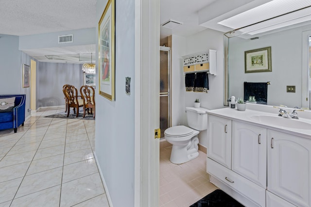 bathroom featuring vanity, tile patterned floors, toilet, a textured ceiling, and walk in shower