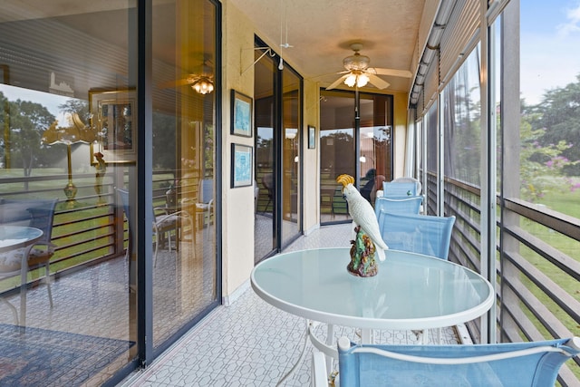 unfurnished sunroom with ceiling fan