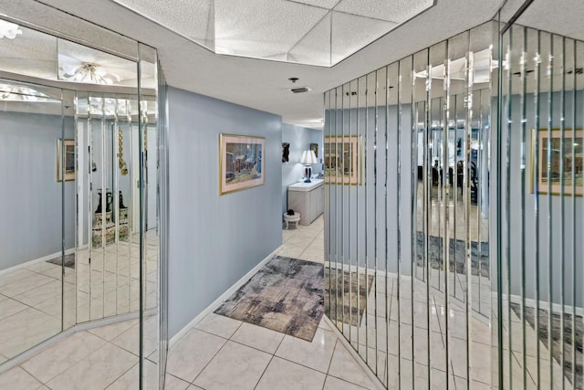 hall featuring tile patterned flooring and a textured ceiling