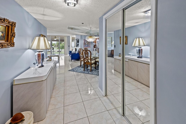 hall featuring light tile patterned flooring and a textured ceiling