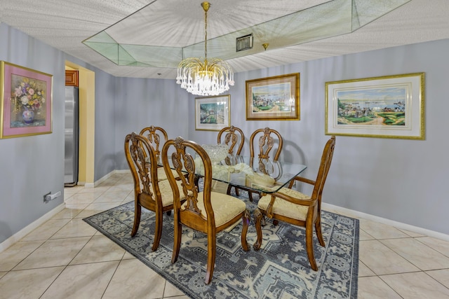 tiled dining space with a chandelier and a textured ceiling