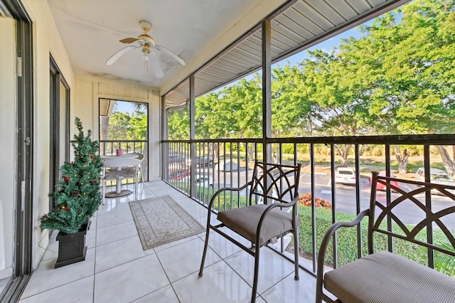 unfurnished sunroom featuring ceiling fan